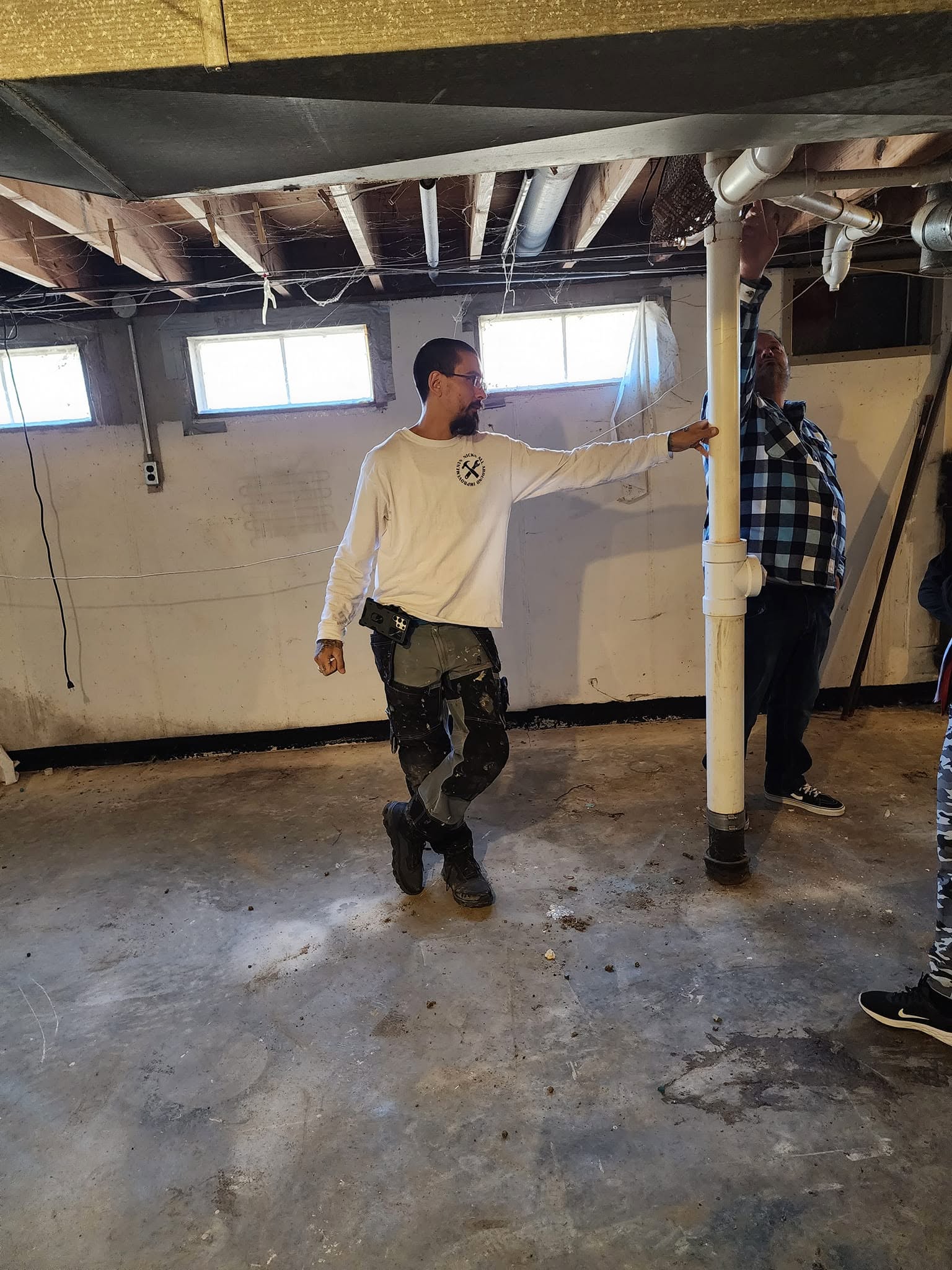Nick Thiele showing investors the plumbing in a basement on a property walk