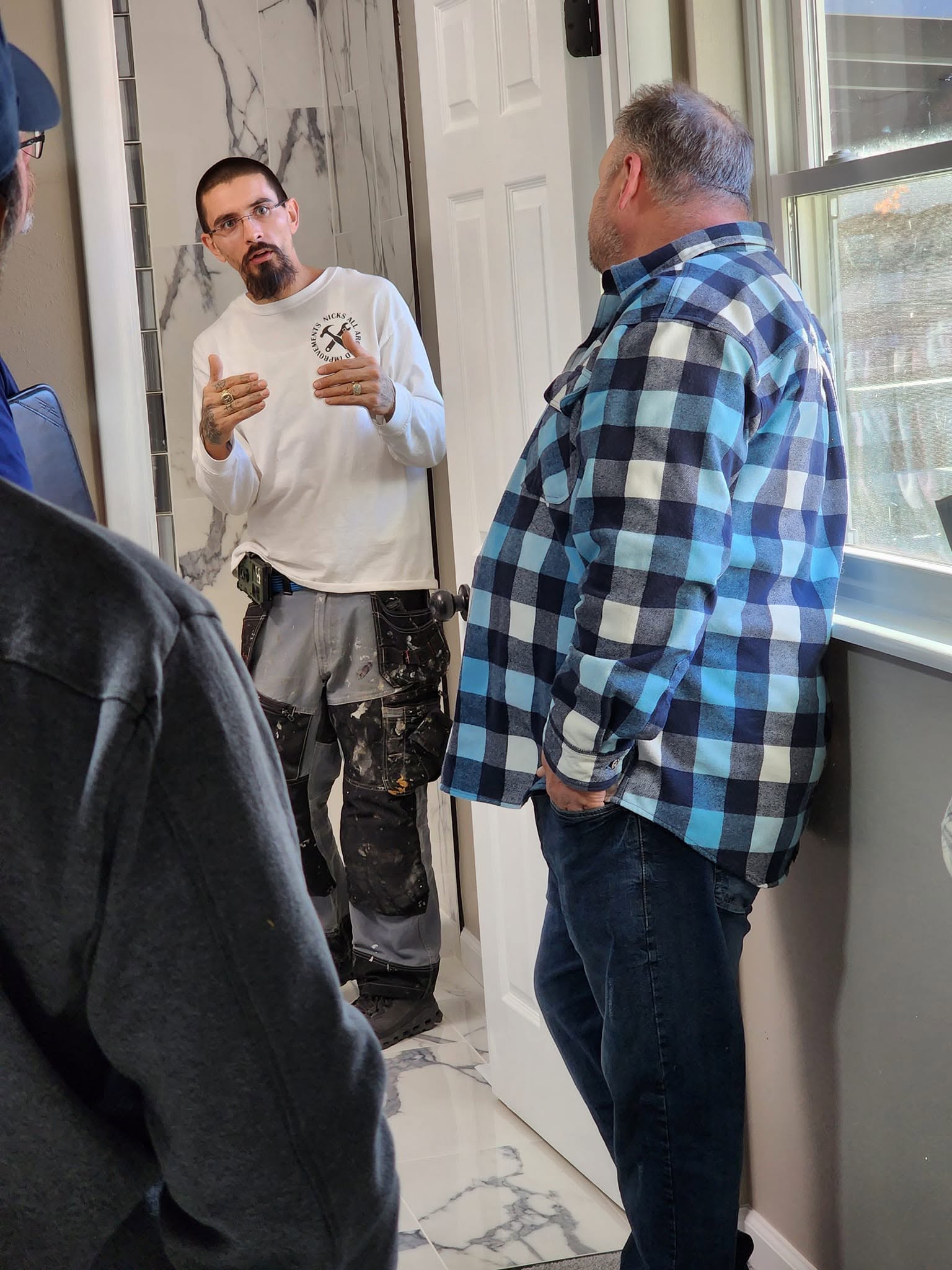 Nick Thiele walking investors through a finished bathroom renovation