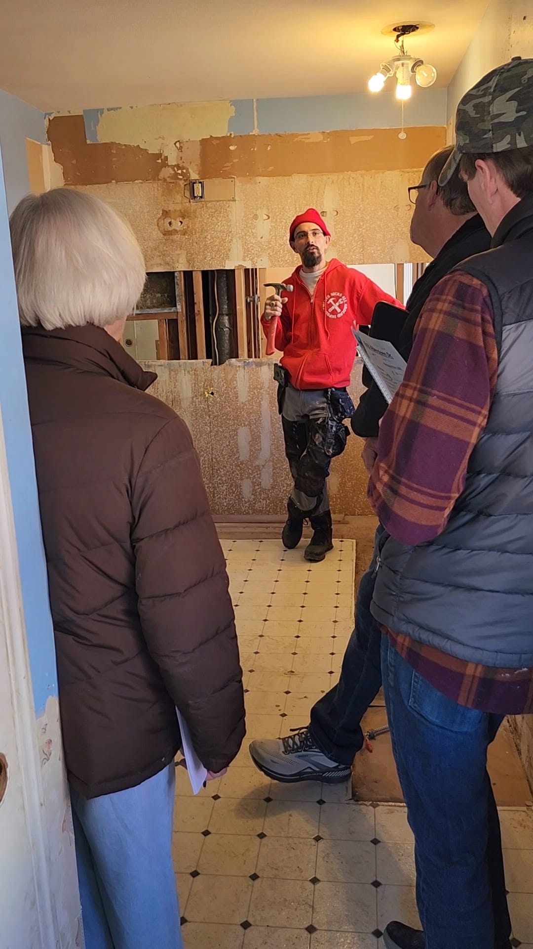 Nick Thiele explaining a gutted bathroom to investors at a rehab site